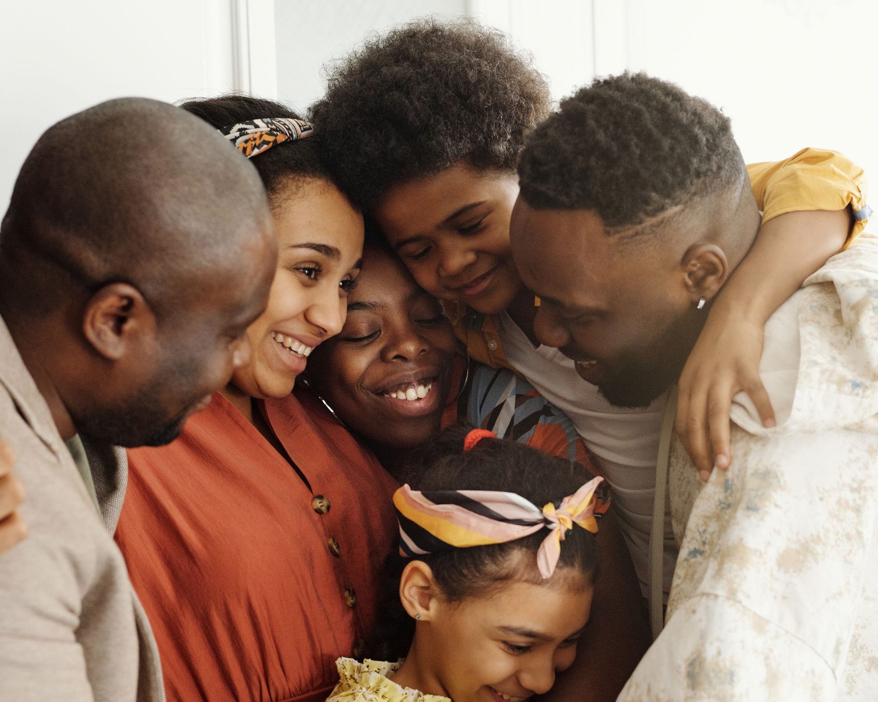Membres d'une famille serrés les uns contre les autres, visages souriants