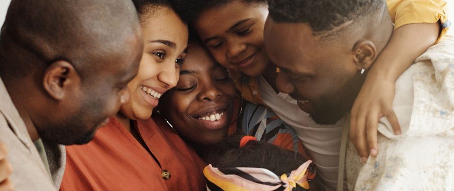 Membres d'une famille serrés les uns contre les autres, visages souriants