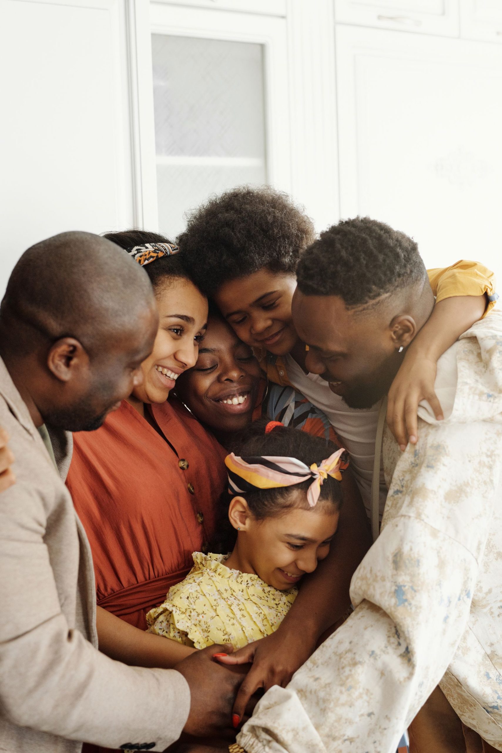 Membres d'une famille serrés les uns contre les autres, visages souriants