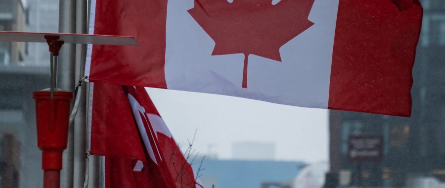 Drapeaux du Canada flottant devant des immeubles modernes en centre-ville